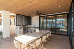 View of patio / terrace with grilling area, a wet bar, ceiling fan, and an outdoor kitchen