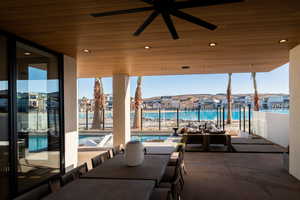 View of patio featuring a community pool, ceiling fan, and a water view