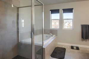 Bathroom with independent shower and bath and tile patterned floors