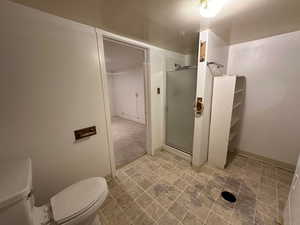 Bathroom with toilet and a shower with shower door