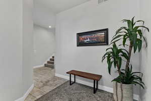 Hallway with stairway and recessed lighting