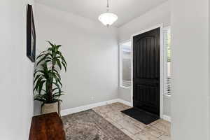 Entryway featuring baseboards and light tile patterned flooring