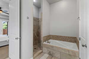 Full bathroom with a garden tub, ensuite bathroom, a tile shower, a ceiling fan, and tile patterned floors