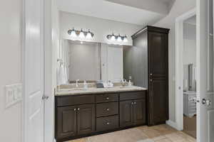 Bathroom with double vanity and tile patterned floors