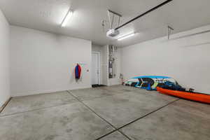 Garage featuring a garage door opener and water heater