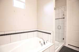 Bathroom featuring plus walk in shower and tile patterned flooring