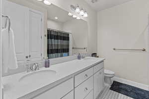 Bathroom with double vanity, tile patterned flooring, a shower with shower curtain, and recessed lighting