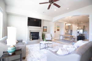 Living room featuring ceiling fan with stunning fireplace