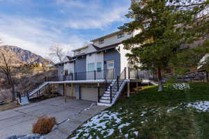 Back of property featuring a garage, a mountain view, and a yard