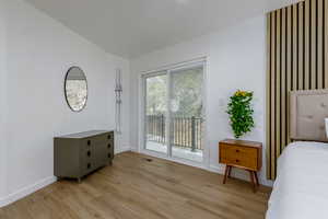 Bedroom with access to exterior and light hardwood / wood-style floors