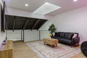 Interior space featuring wood-type flooring and lofted ceiling with skylight