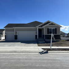 Craftsman-style house with a garage, driveway, and roof with shingles