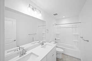 Full bathroom featuring bathtub / shower combination, vanity, tile patterned flooring, and toilet