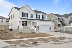 View of front of property featuring cooling unit, a porch, and a garage