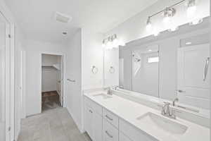 Bathroom featuring vanity, tile patterned floors, and walk in shower