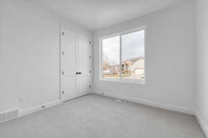 Unfurnished room featuring light colored carpet