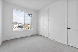 Unfurnished bedroom with light carpet