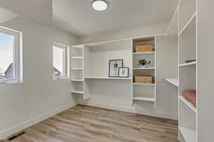 Spacious closet featuring light hardwood / wood-style flooring