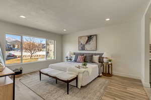 Bedroom with a textured ceiling and light hardwood / wood-style flooring