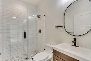 Bathroom with vanity, an enclosed shower, and toilet