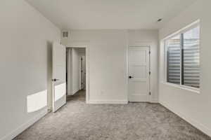 Unfurnished bedroom with light colored carpet