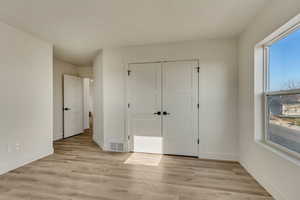 Unfurnished bedroom with a closet and light wood-type flooring