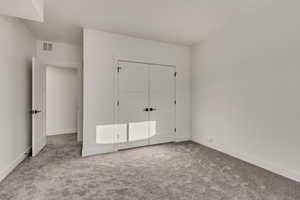 Unfurnished bedroom featuring a closet and carpet