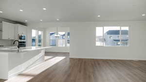 Kitchen featuring stainless steel microwave, sink, oven, white cabinets, and a kitchen breakfast bar