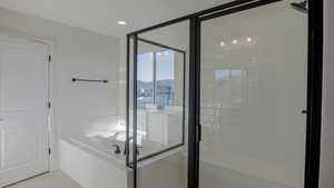 Bathroom featuring tile patterned flooring and shower with separate bathtub