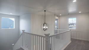 Hall with a notable chandelier and dark carpet