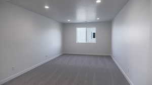 Carpeted spare room featuring a textured ceiling