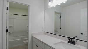 Bathroom featuring tile patterned flooring, vanity, and toilet