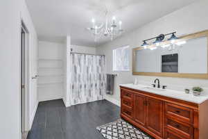 Primary bathroom with vanity and an inviting chandelier