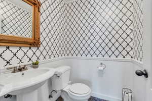 Main floor half bathroom with sink and toilet