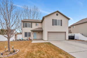 Front facade featuring a garage and a front yard