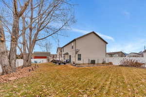 Rear view of house featuring a yard and central air condition unit