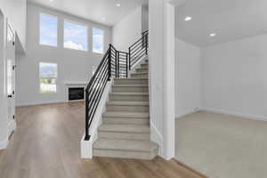 Staircase featuring hardwood / wood-style flooring and a high ceiling