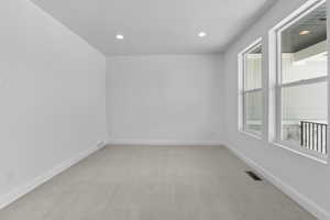 Unfurnished room featuring light carpet