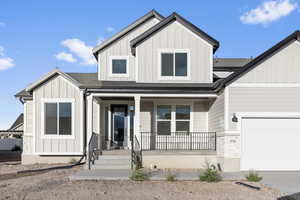 View of front of home with a porch and a garage