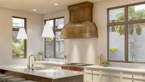 Kitchen featuring hanging light fixtures, plenty of natural light, sink, and white cabinets