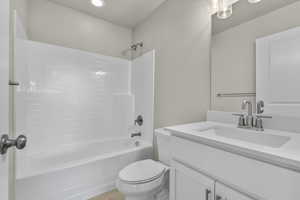 Full bathroom with bathing tub / shower combination, vanity, and toilet