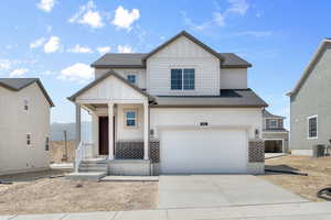 View of front of house with central AC unit and a garage