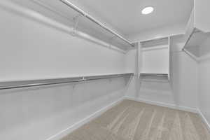 Walk in closet with light colored carpet