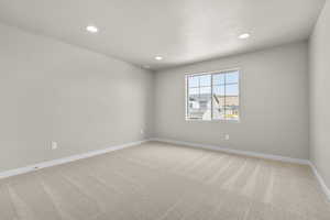 Spare room featuring carpet and a textured ceiling