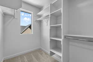 Walk in closet with light carpet