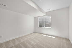 Carpeted empty room with a textured ceiling