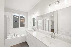 Bathroom with independent shower and bath, vanity, and tile patterned flooring