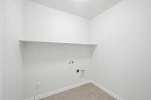 Washroom with washer hookup, light tile patterned floors, and electric dryer hookup