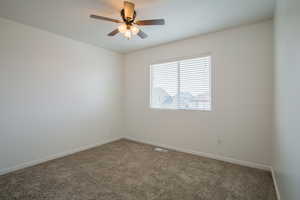 Carpeted spare room with ceiling fan