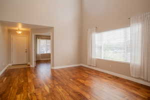 Unfurnished room featuring hardwood / wood-style flooring and a high ceiling